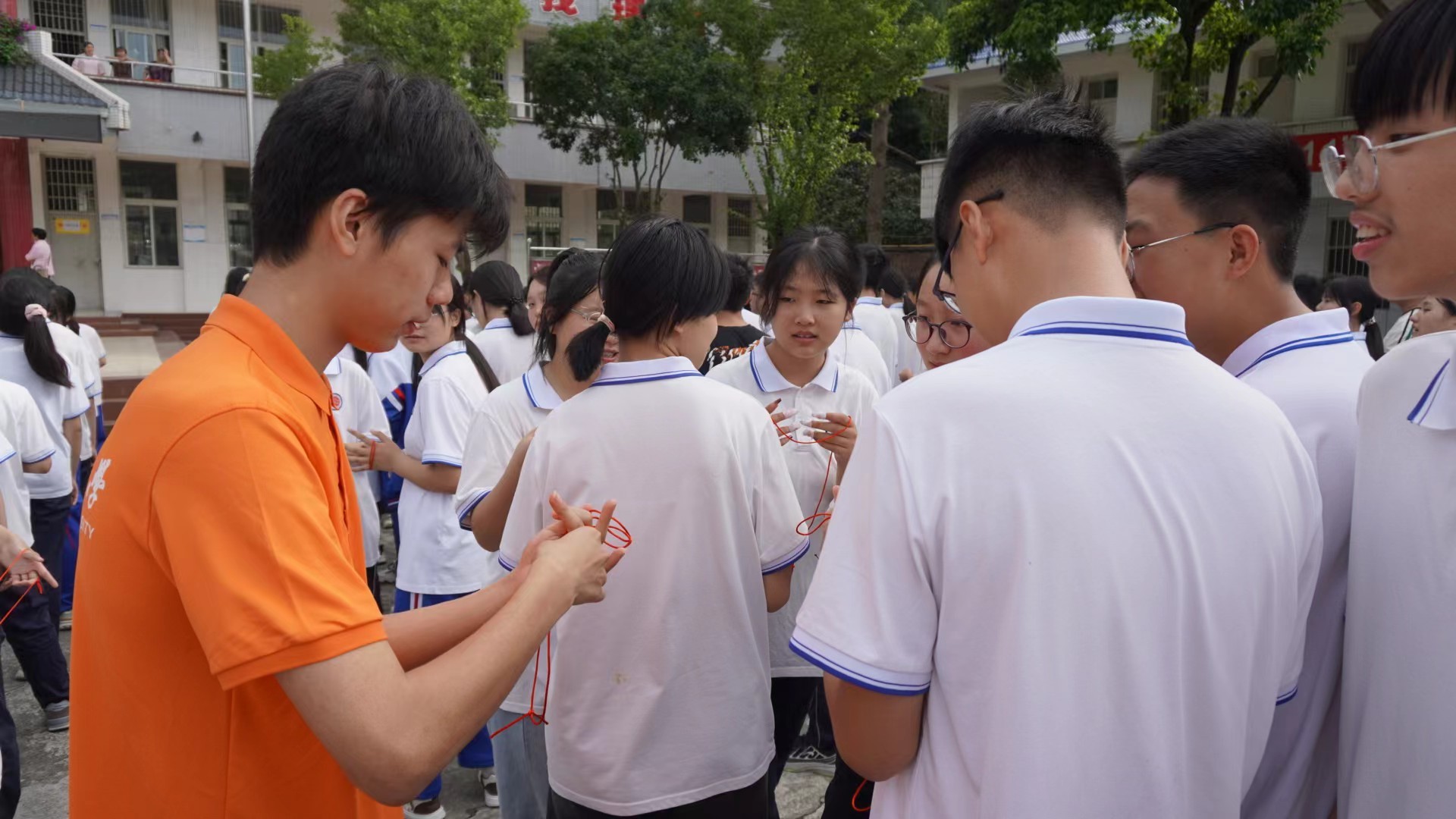 图为队员在学生群体中教学中国结编织。 梁虞麟 摄.jpg